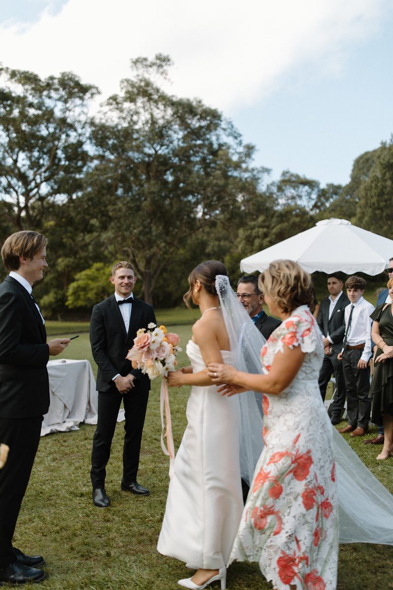 Bride and groom laughing with their guests mid-ceremony