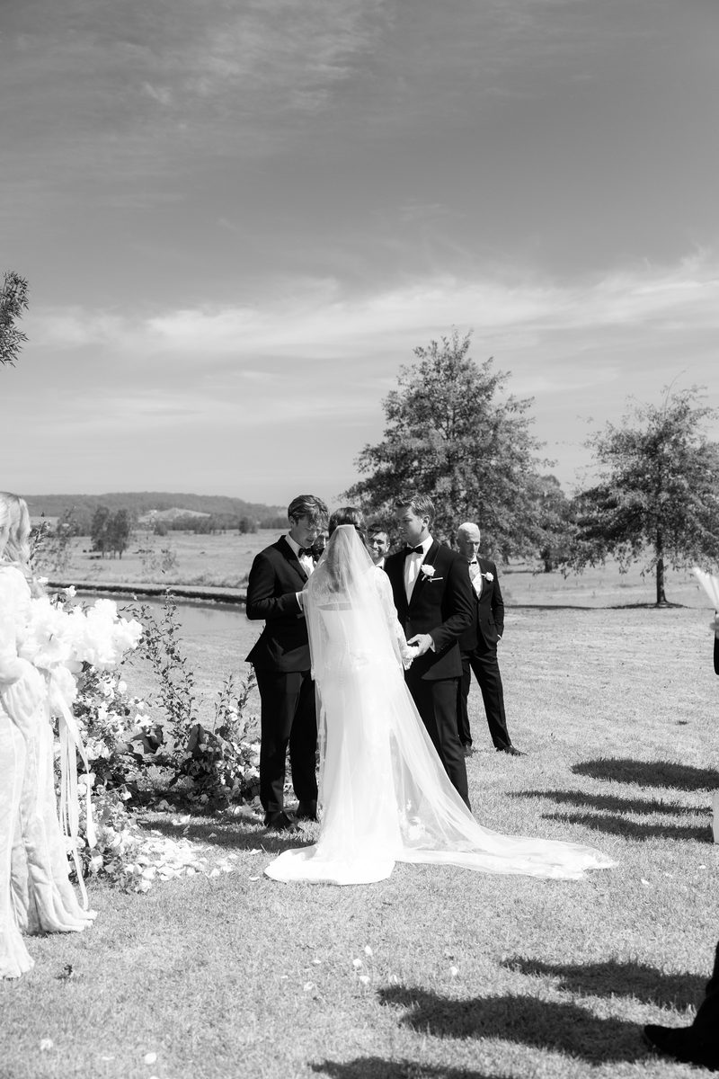 Clifftop ceremony above the bay, in black and white