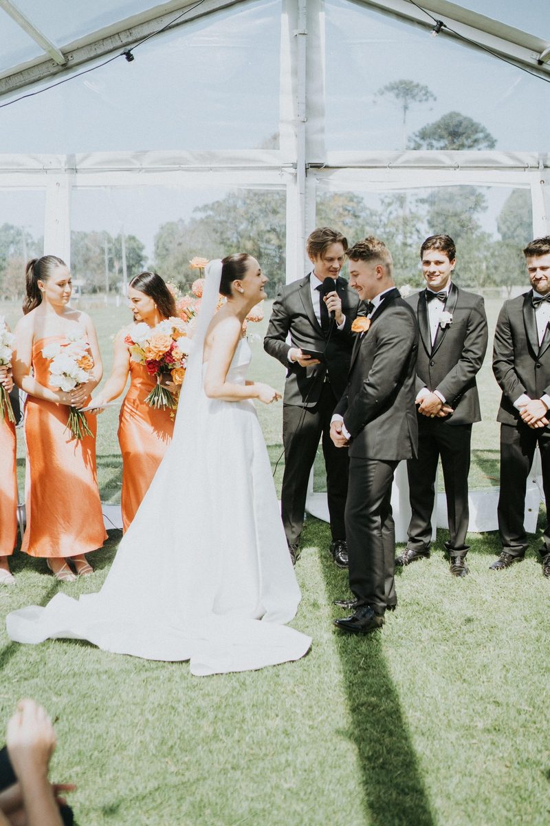 The wedding party gathered on the lawn in the sunshine