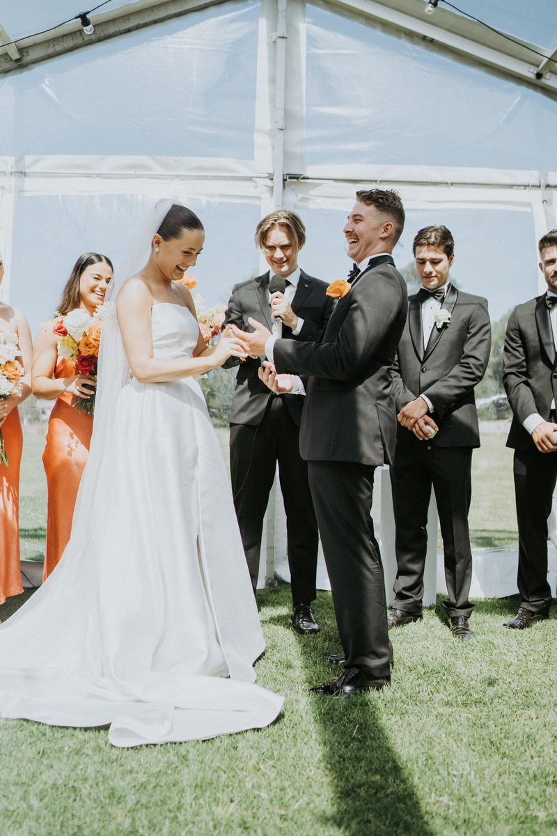 Signing moment surrounded by the wedding party