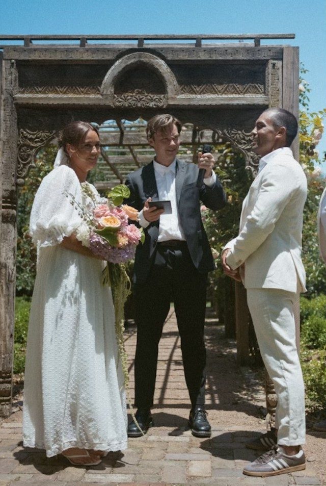 Intimate garden ceremony beneath a stone arch